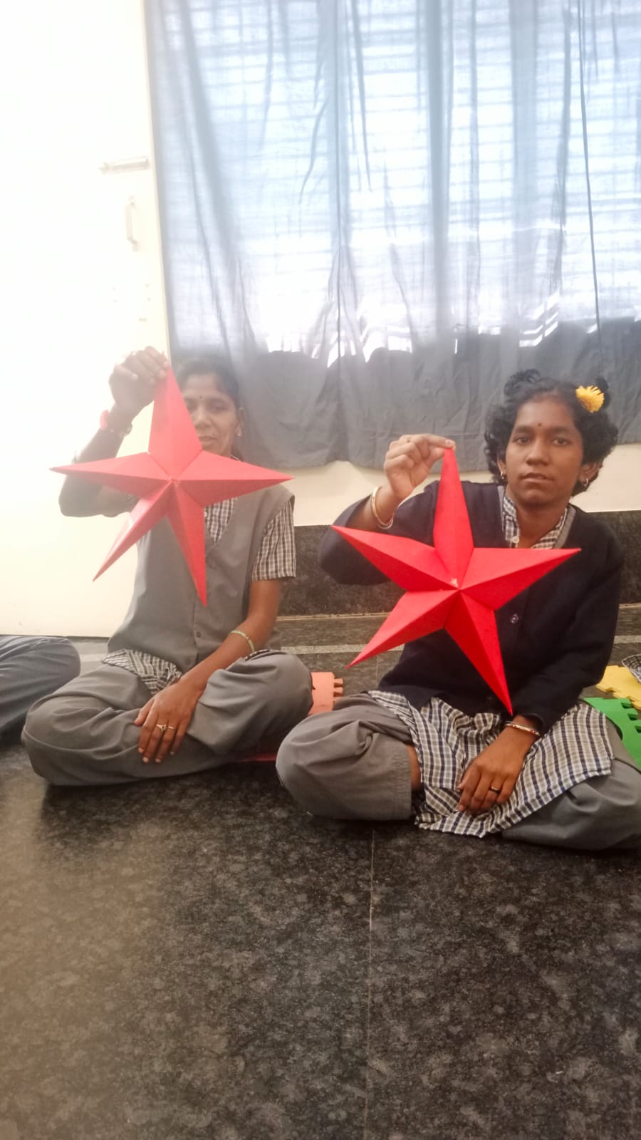 Students displaying red paper star crafts